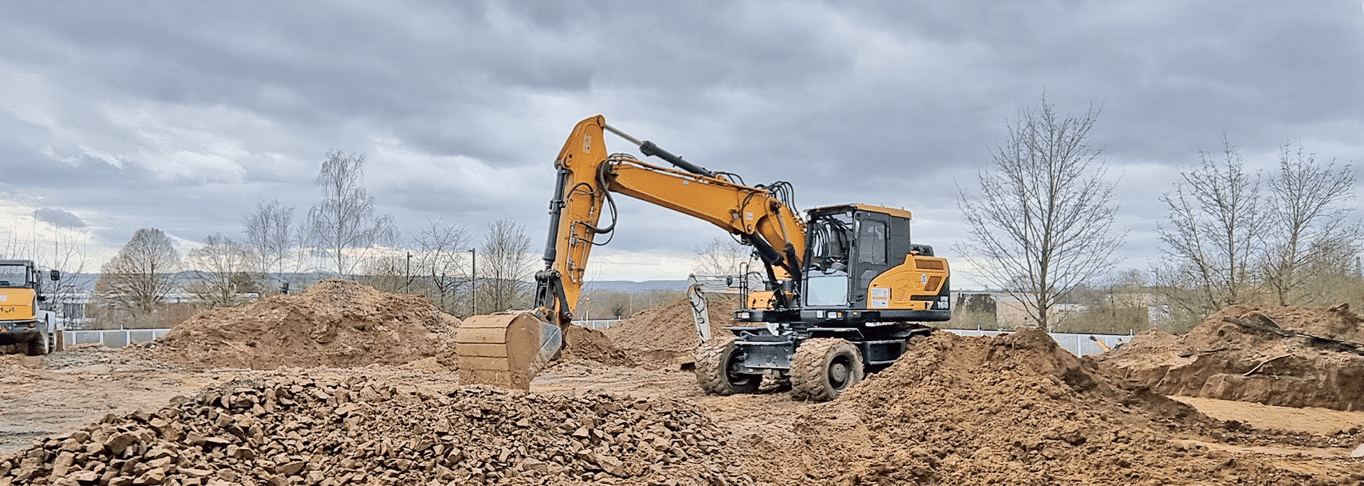 Baustelle mit einem Bagger im Vordergrund